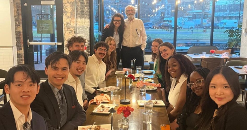 The inaugural class of the “Washington, D.C. Trek: Exploring the Political Ecosystem and Career Paths” course smile for a photo around a dining table. 