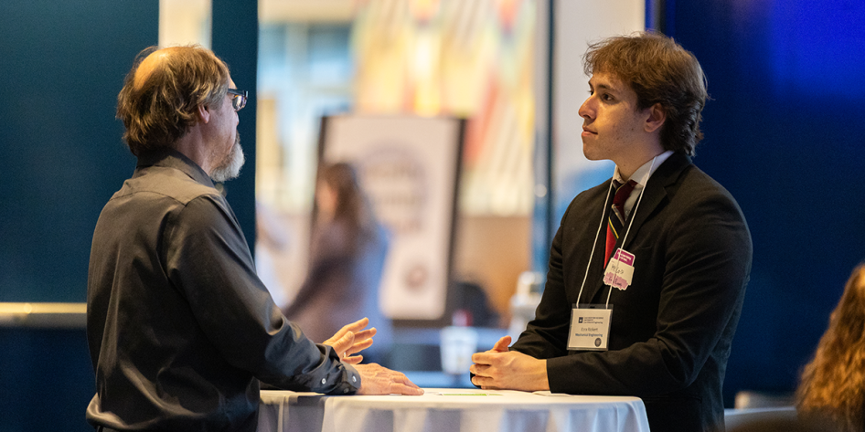 Photo of a student talking to faculty at E-Week's Dean's Networking Reception