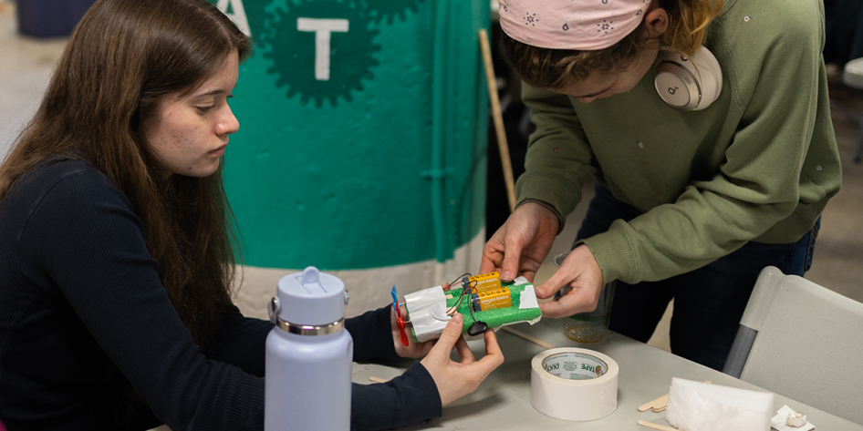 Photo of students building a small boat out of styrofoam