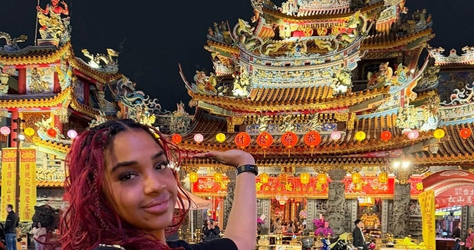 Ozuna Blanco stands in front of a brightly lit Taiwanese temple.