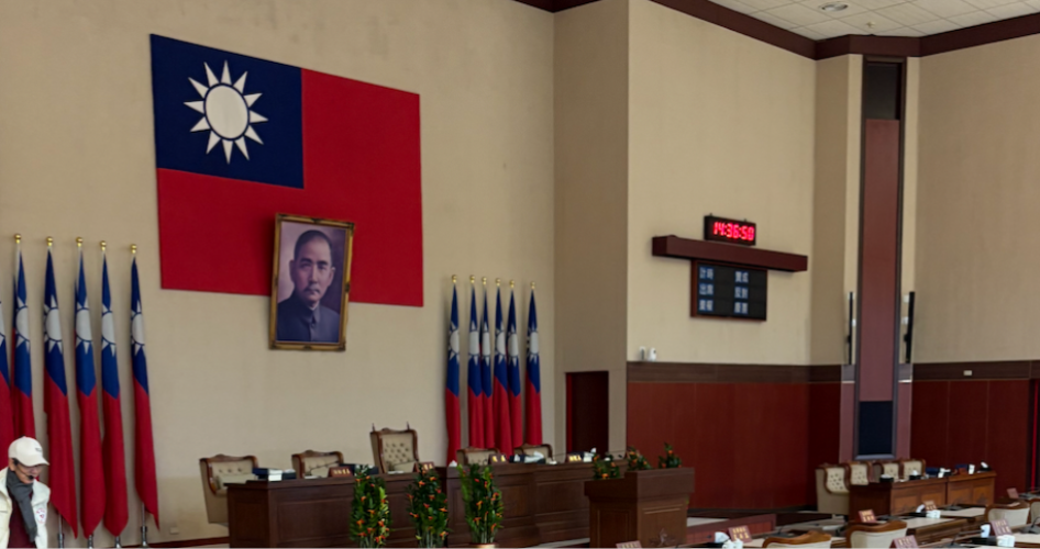 A meeting room featuring a large Taiwanese flag and a podium.