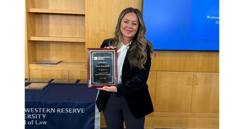 Anat Alon-Beck holding a plaque