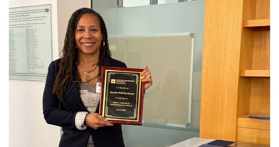 Ayesha Bell Hardaway holding a plaque
