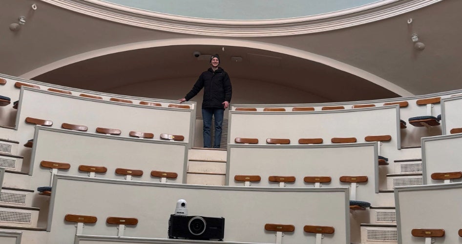 Greg Gardner stands in a room at the top of stairs.