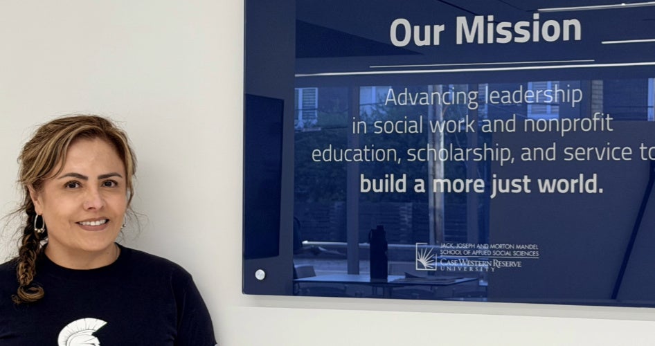 Edith Cabrera with a sign with the Mandel School mission