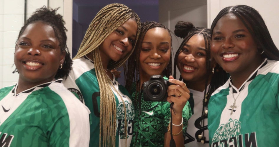 Five women pose in green and white Nigeria jerseys.
