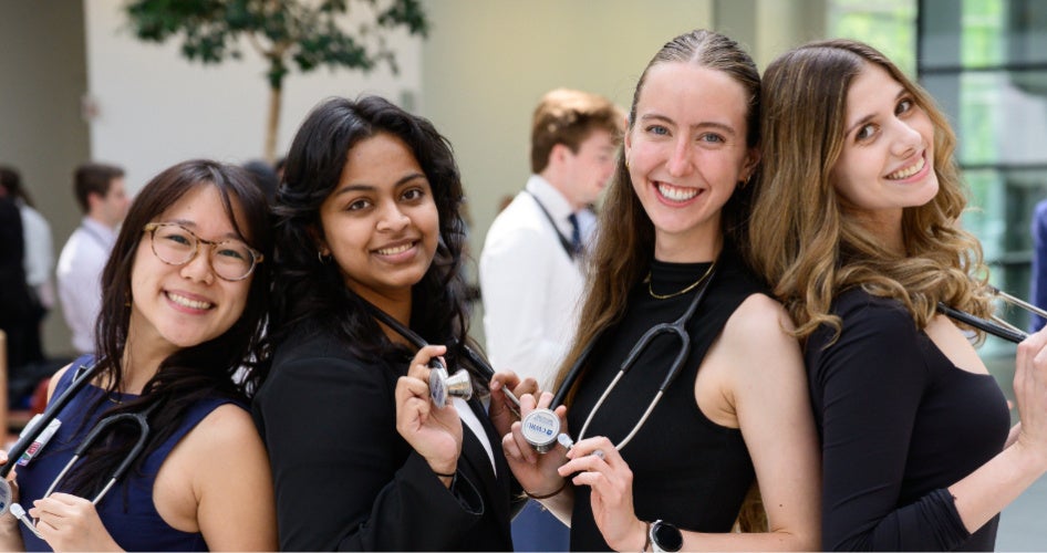 four students posing with their stethoscopes