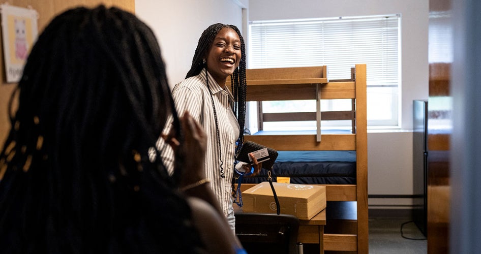 A new CWRU student explores her new room on campus as a family member watches