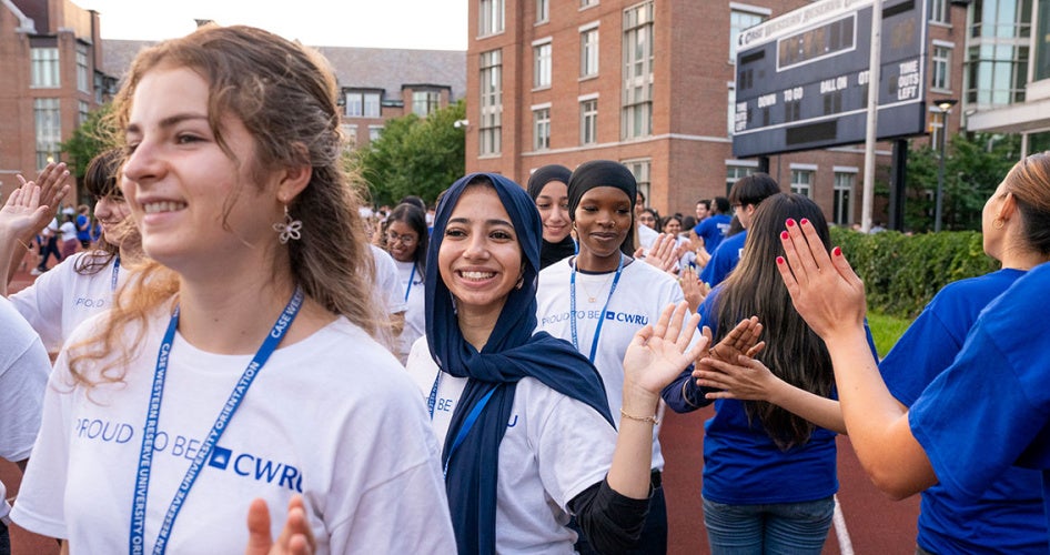 Orientation leaders welcome students as they file into DiSanto Field for tradition