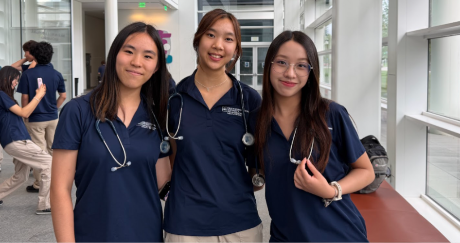 Three women smile after the stethoscope ceremony.