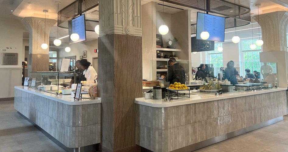 Employees in Tomlinson Hall dining area work at the central service island