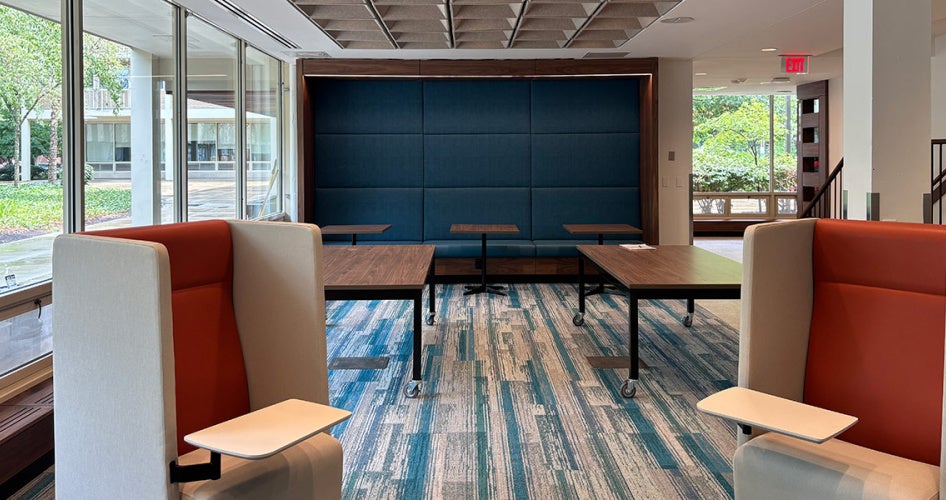 Photo of the empty lobby area of the renovated Sherman House with high-backed chairs and tables