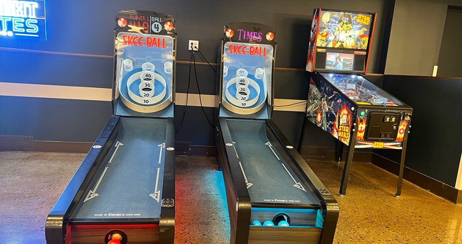 Photo of two skee ball games and a pinball machine in Knight Bytes