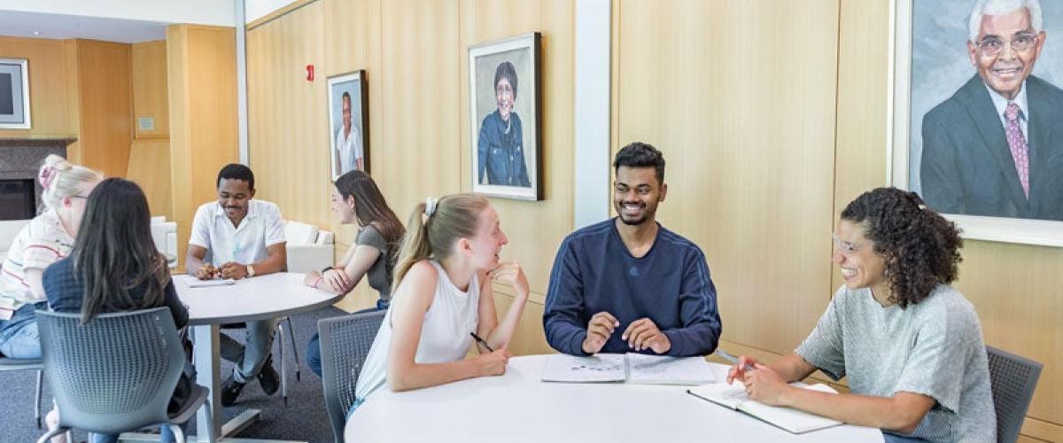 Two tables of students in Mandel Center talking