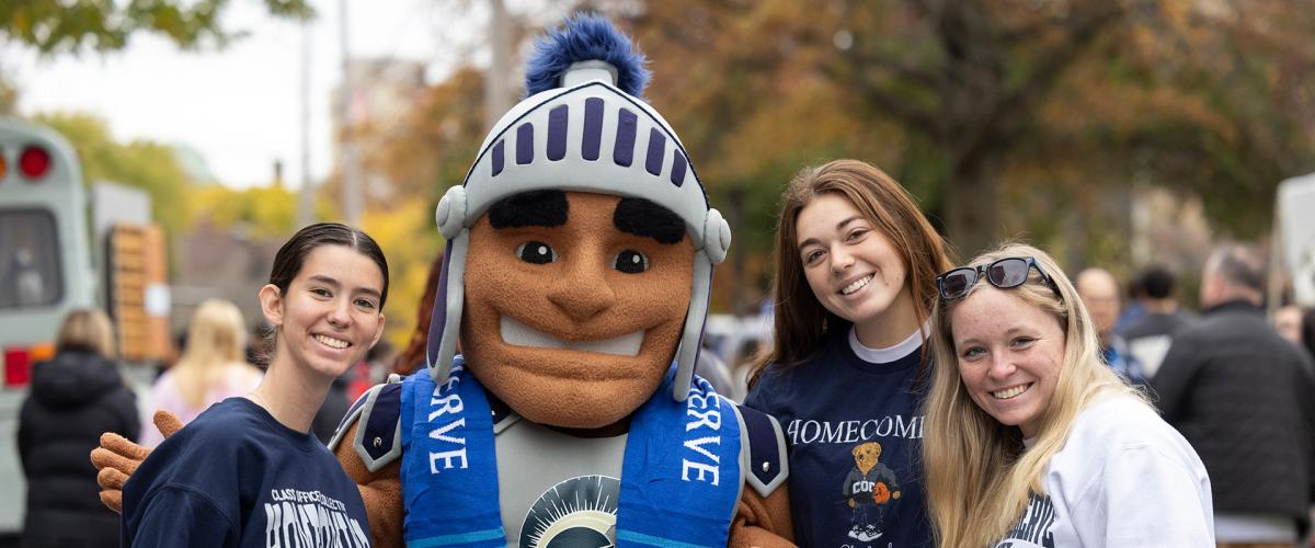 Students stand in CWRU gear for a photo with Spartie at homecoming