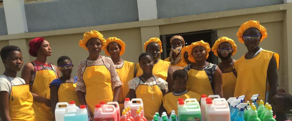 An image of a group of girls standing behind a table.
