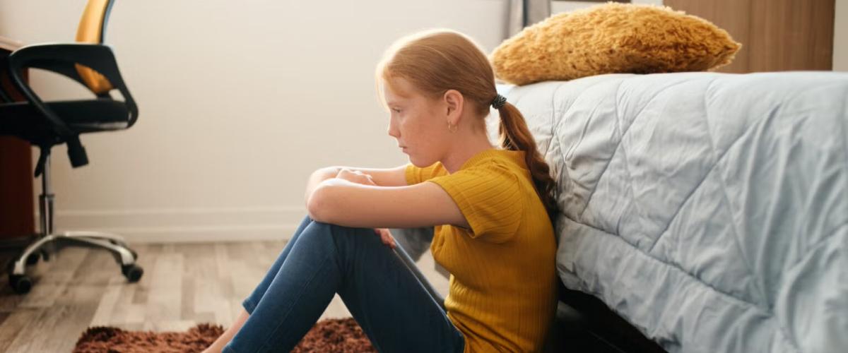 Child sitting on bedroom floor
