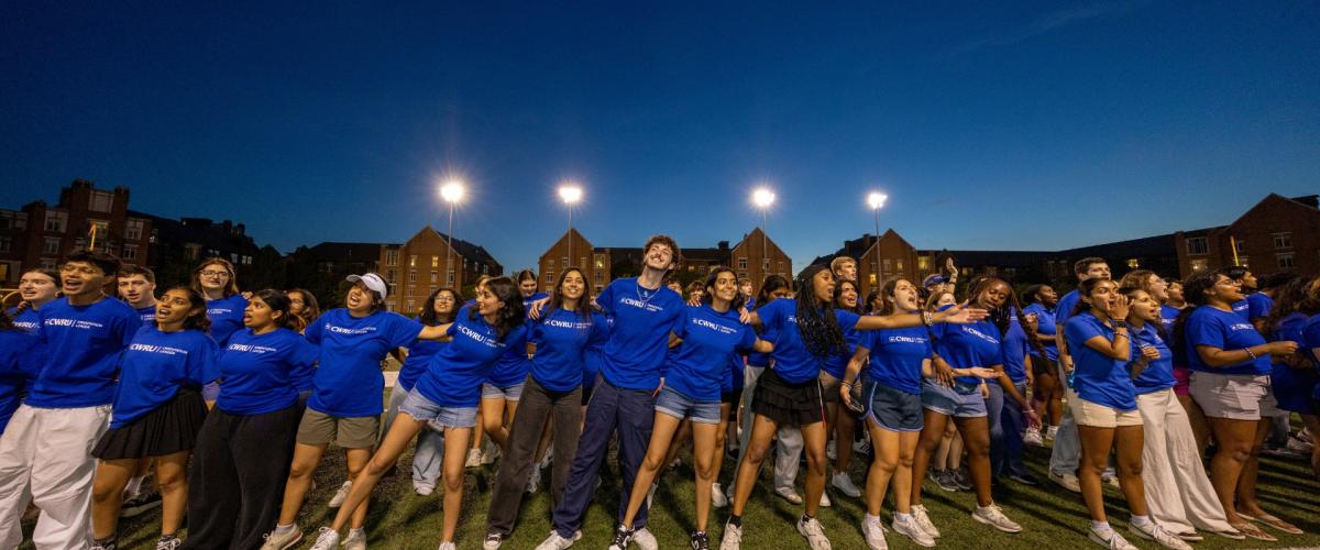 Orientation leaders link arms and belt out tunes at DiSanto Field to give new and transfer students a warm Discover Week welcome.