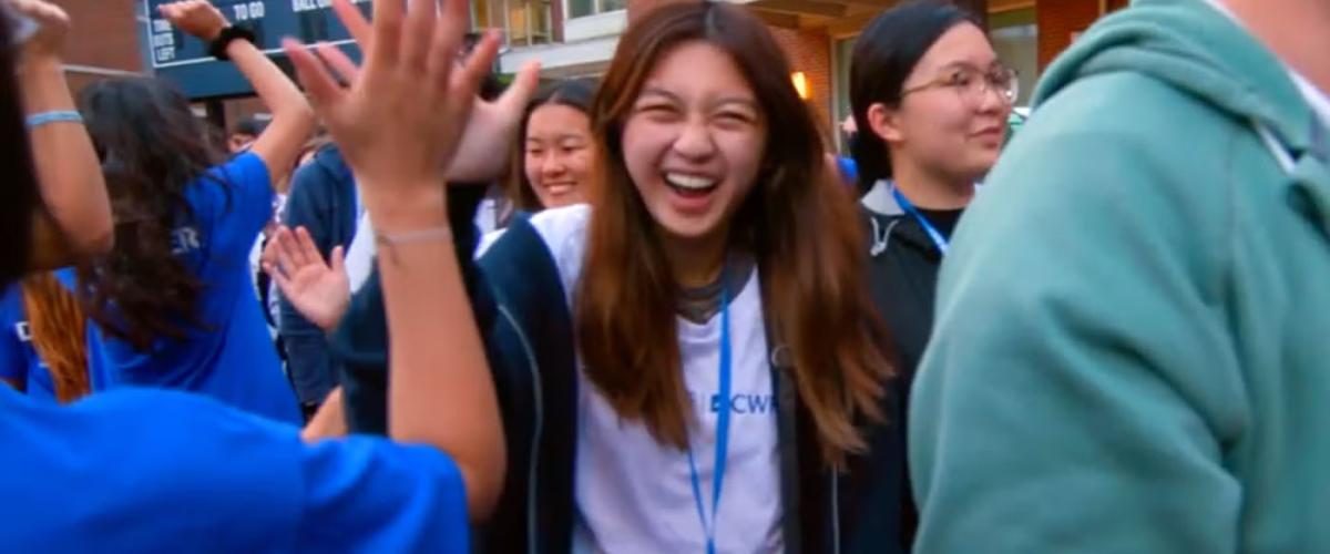 Student laughing in a crowd