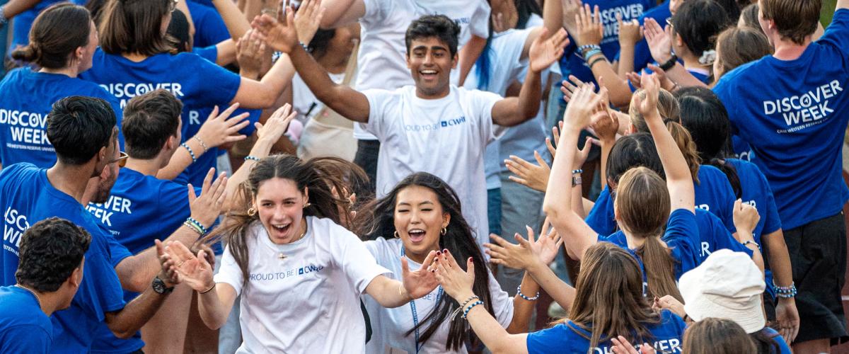 Photo of CWRU Class of 2029 students running through a tunnel of orientation leaders during Discover Week