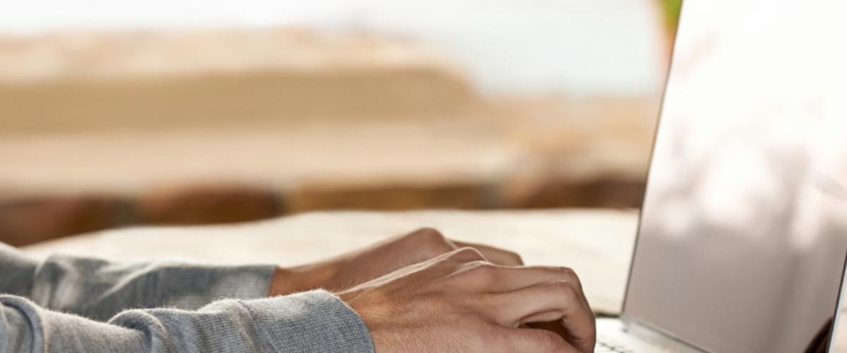Close up photo of hands typing on laptop