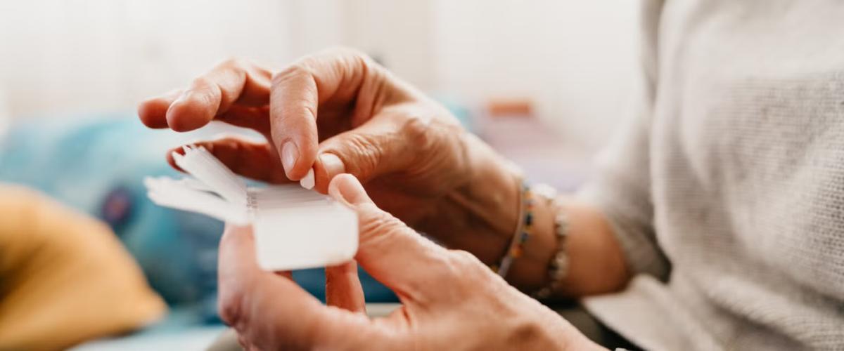 Person holding pill container and pill