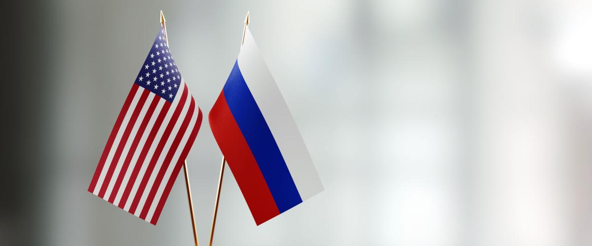 Photo illustration of USA and Russian flags on a desk
