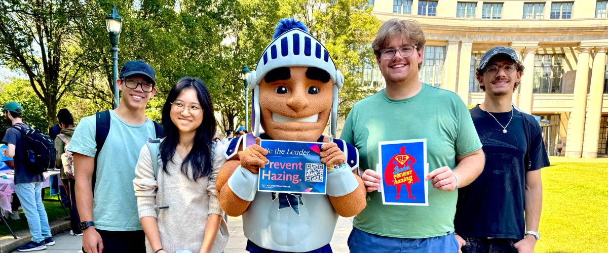Photo of CWRU students posing with Spartie with anti-hazing signage
