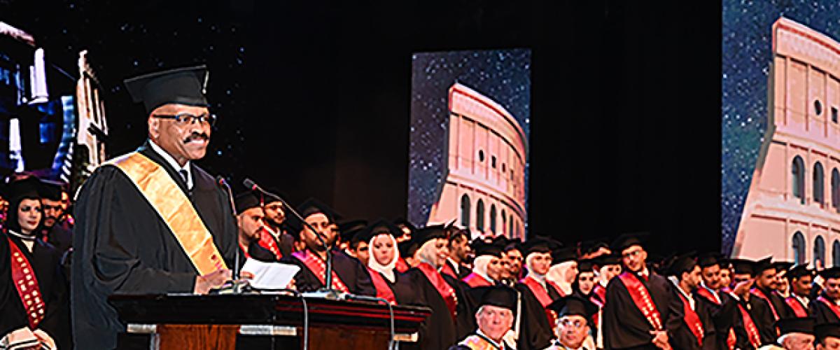 Dean Chance stands at a podium to give the commencement address at Future University in Cairo