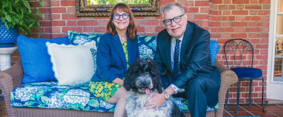 President Kaler and Mrs. Kaler pose for a photo on their porch with their dog