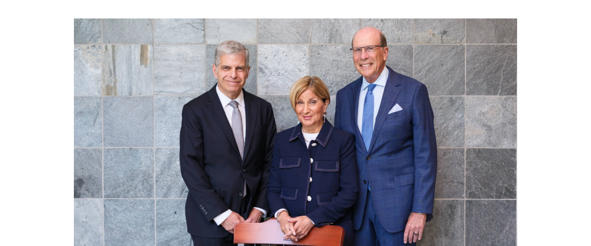 Three people standing behind a chair