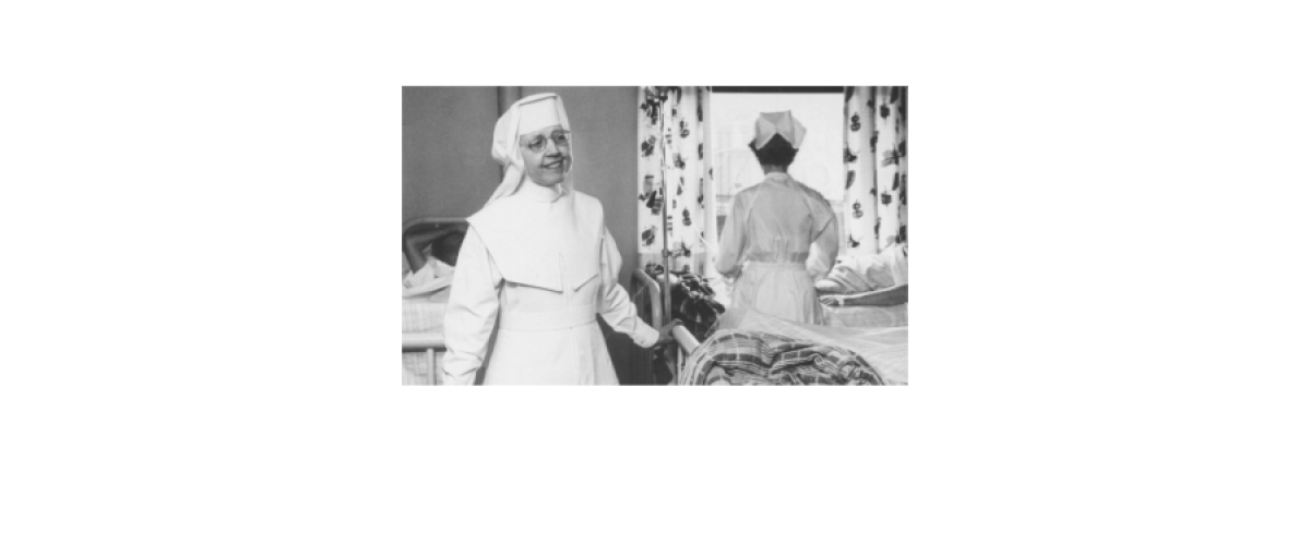 Black and White photo of smiling person wearing a habit 