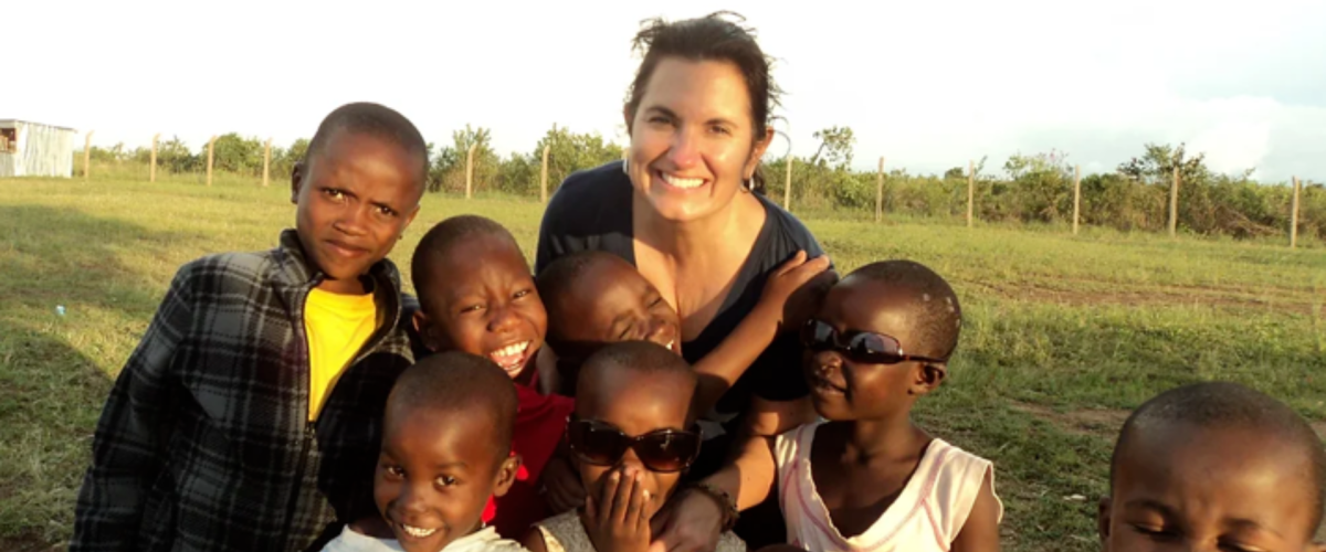 Lisa Alverto outside in Africa with young smiling children