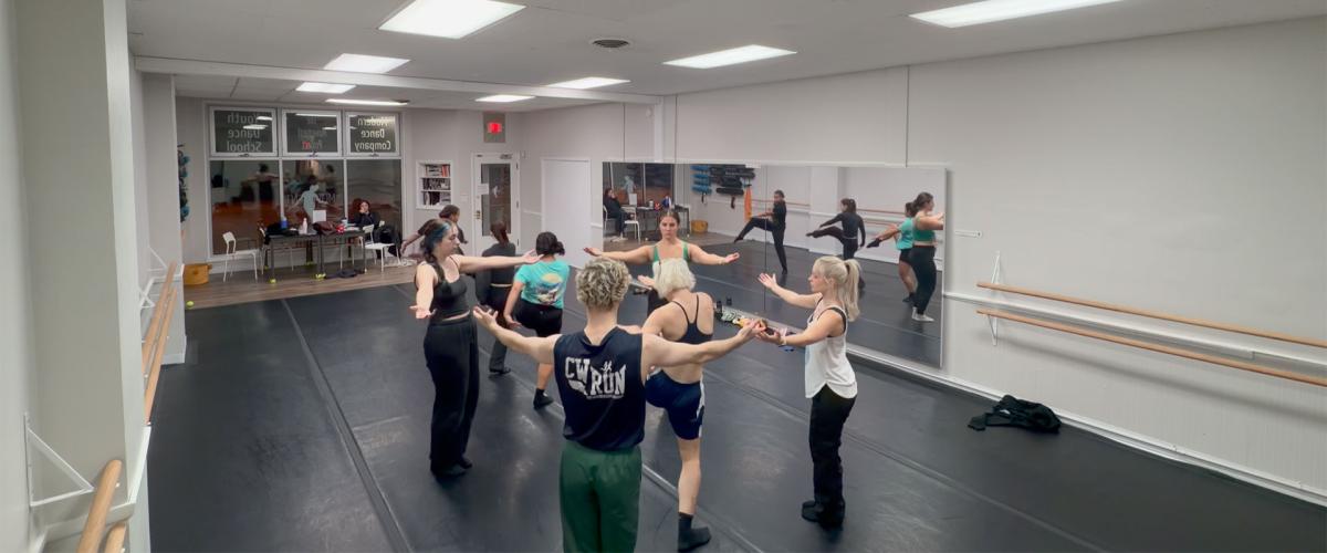 Photo of dancers gathered in a circle during a rehearsal
