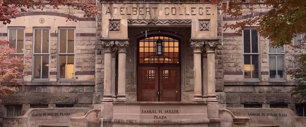 Adelbert Hall surrounded by red fall foliage with a light layer of snow. 