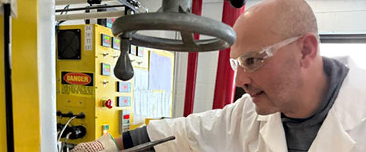 João Maia in a lab coat and safety glasses, working in his lab.