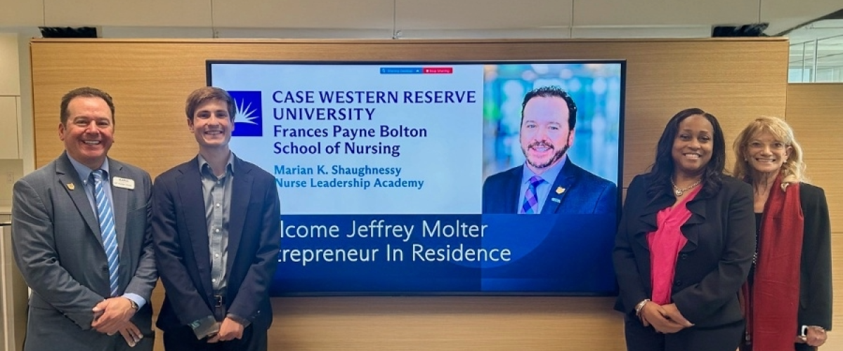 Jeffrey Molter standing next to a digital screen 