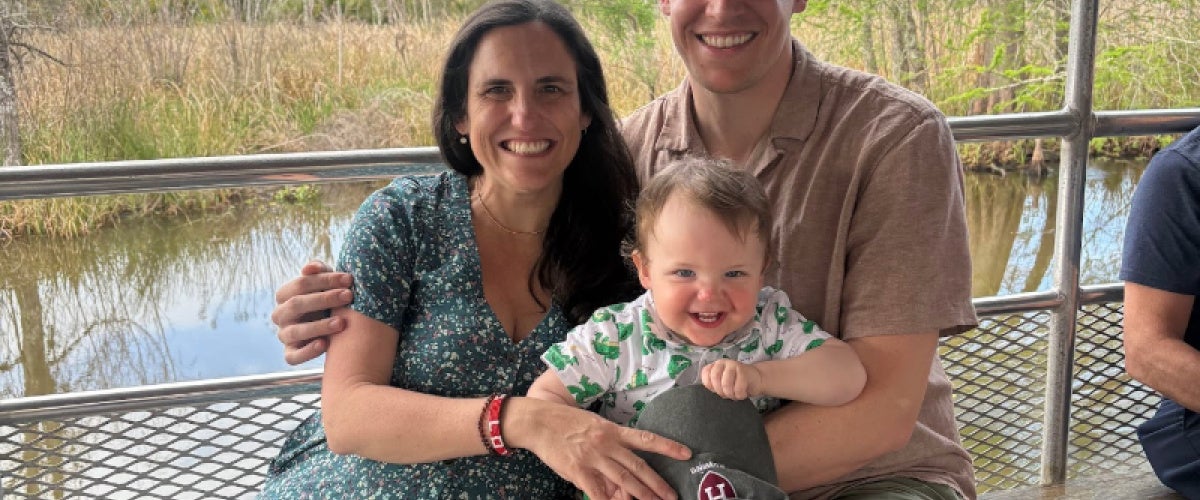 Alexander Richards riding in a boat on a bayou with his wife and child