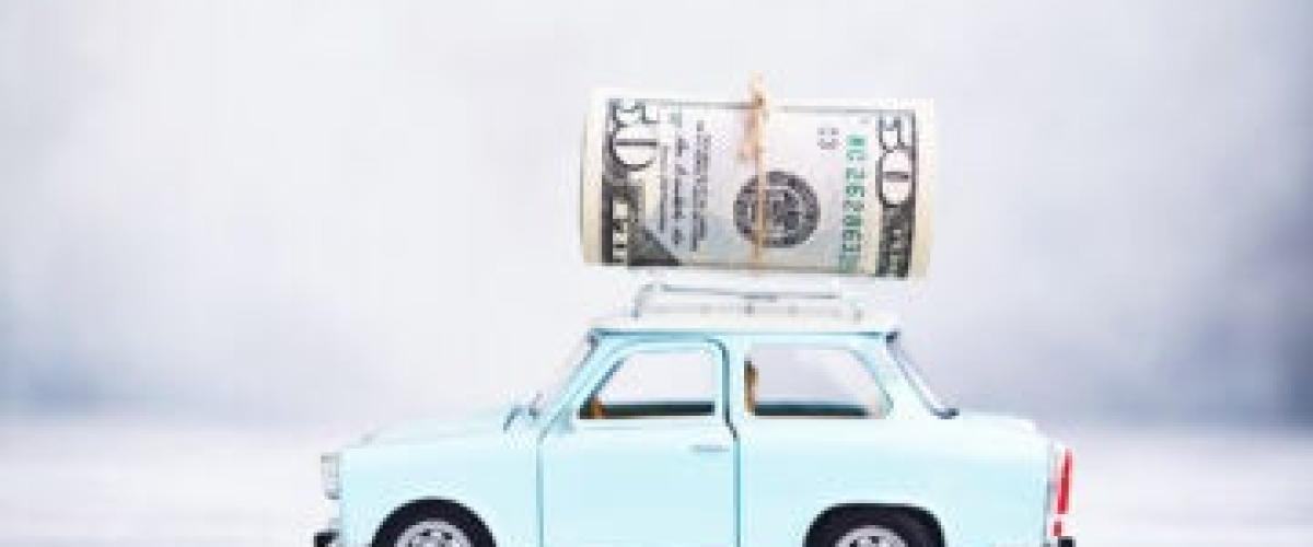 Money on top of small blue car