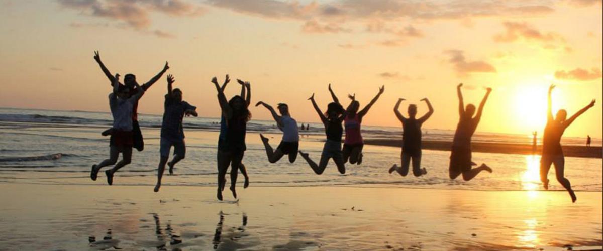 students-jumping-beach