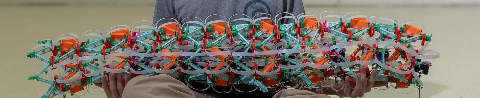 Student holding a colorful mechanical engineering device