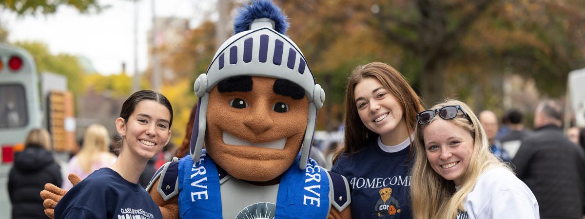 Students stand in CWRU gear for a photo with Spartie at homecoming