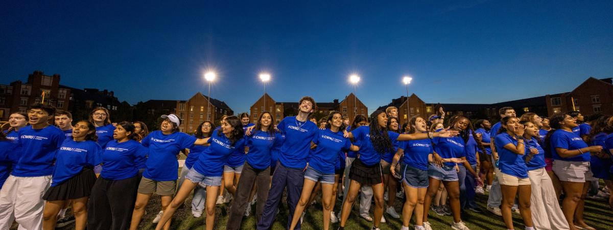 Orientation leaders link arms and belt out tunes at DiSanto Field to give new and transfer students a warm Discover Week welcome.