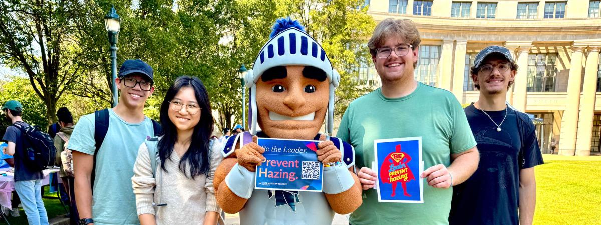 Photo of CWRU students posing with Spartie with anti-hazing signage