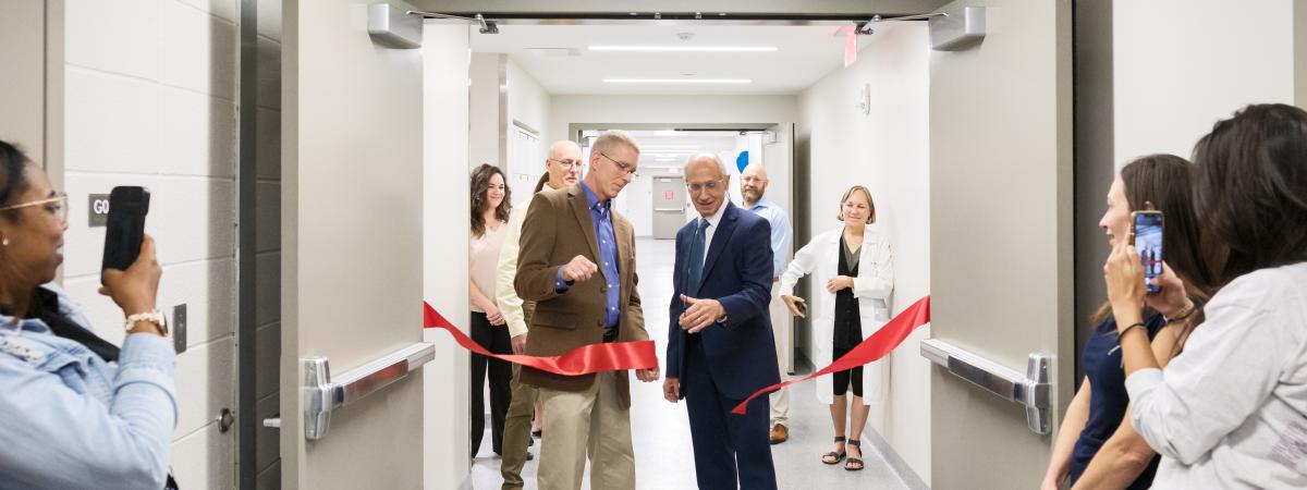 Stan Gerson and Darin Croft cutting a red ribbon at the doors of the new anatomy lab