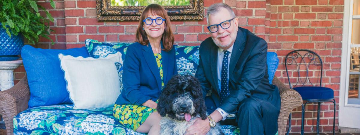 President Kaler and Mrs. Kaler pose for a photo on their porch with their dog
