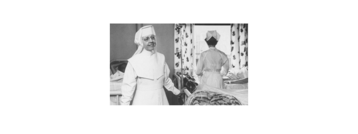 Black and White photo of smiling person wearing a habit 