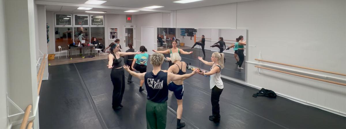 Photo of dancers gathered in a circle during a rehearsal