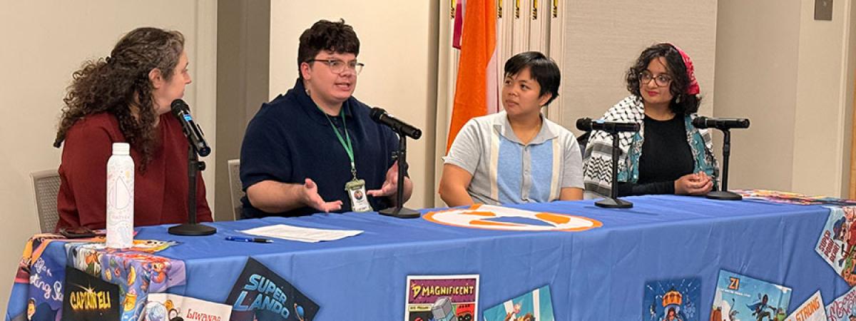 Photo of three CWRU students and Lisa Kollins speaking about a new art display for The Superhero Project