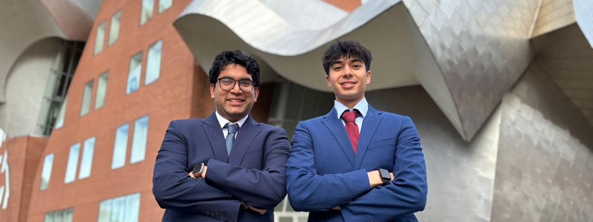 Dev Gupta and Sunveer Chugh pose for a photo in front of the Peter B. Lewis Building